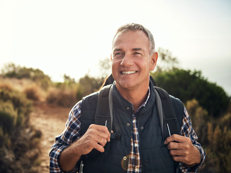 older man hiking on trail