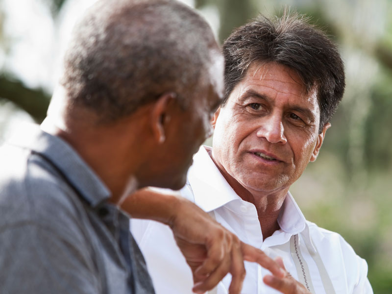 two men talking outdoors