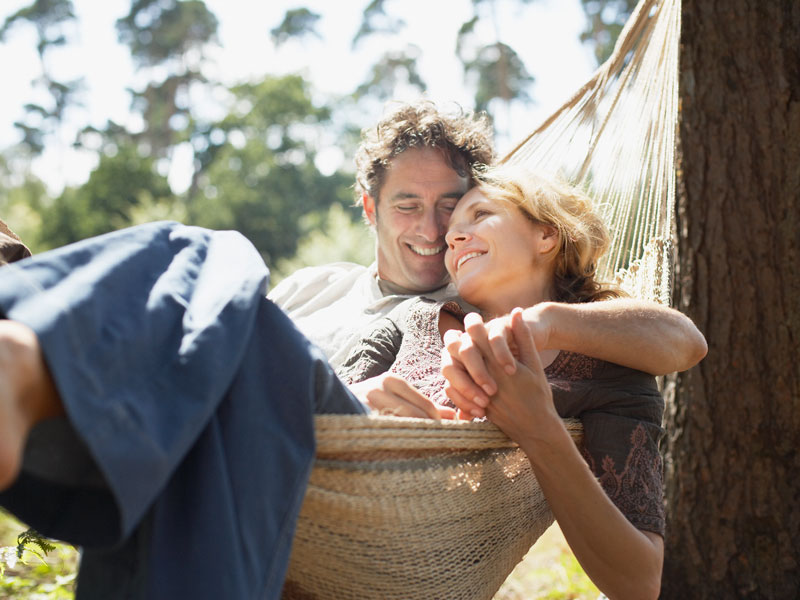 man and woman enjoying a nice day in a hammock