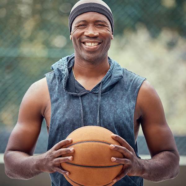 a man holding basketball in his hands smiling